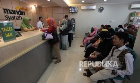 Petugas layanan nasabah melayani calon jamaah haji yang akan melakukan pelunasan Biaya Penyelenggaraan Ibadah Haji (BPIH) di Kantor Cabang Mandiri Syariah Area Bekasi, Jawa Barat, Selasa (19/3/2019).