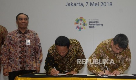 SVP Micro Banking Bank Mandiri Wawan Setiawan (kedua kiri) melakukan penandatanganan kerja sama dengan Managing Director Grab Indonesia Ridzki Kramadibrata (kanan) disaksikan Pejabat Eksekutif Retail Banking Bank Mandiri Donsuwan Simatupang (kiri) di Jakarta, Senin (7/5).