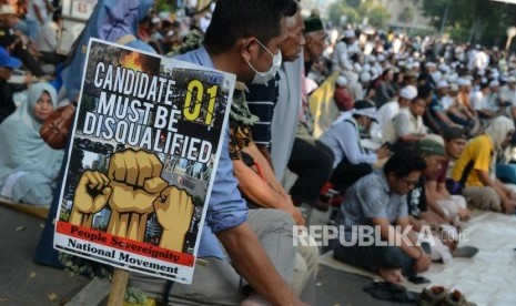 Sejumlah massa saat menggelar doa bersama pada Aksi Tahlil Akbar 266 di Jalan Medan Merdeka Barat, Jakarta, Rabu (26/6).