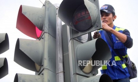 Petugas Dinas Perhubungan DKI Jakarta memperbaiki lampu pengatur lalu lintas di Jalan Harmoni, Jakarta, Selasa (13/2).