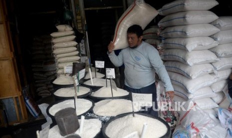 Pedagang memindahkan karung beras di salah satu agen penjual beras di Kawasan Manggarai, Jakarta, Ahad (4/3).