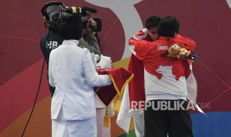 Atlet Wushu Indonesia Edgar Xavier Marvelo   menerima ucapan dari Ketua umum pengurus besar Wushu Indonesia , Airlangga Hartarto  saat prosesi penyerahan medali cabang olahraga Wushu Changquan Putra di Hall B, beberapa waktu lalu.