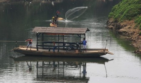 Penarik eretan membawa pelanggannya menyebrangi sungai Cisadane di Neglasari, Tangerang, Banten, Selasa (5/9).