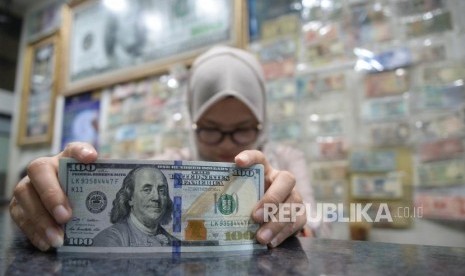 Cadangan Devisa Susut. Pegawai menghitung mata uang dolar AS di jasa penukaran mata uang, Jakarta.