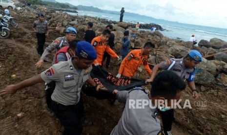 Sejumlah petugas gabungan mengevakuasi jenazah korban tsunami di Desa Way Muli, Kalianda, Lampung Selatan, Senin (24/12).