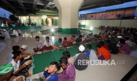 Sejumlah anak menyantap makanan saat berbuka puasa bersama di Masjid Babah Alun, Jalan Papanggo, Tangjung Priok, Jakarta, Rabu (23/5).