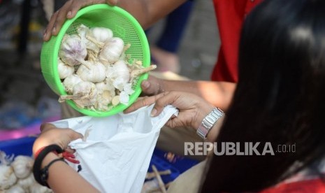 Petugas menimbang bawang putih ketika gelar pangan murah (ilustrasi)