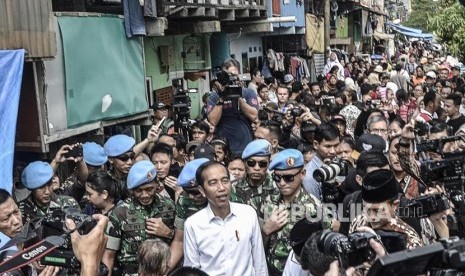 Capres Petahana Joko Widodo (tengah) menyapa warga usai pidato kemenangan sebagai Presiden periode 2019-2024 di Kampung deret,Tanah tinggi,Johor baru, Jakarta Pusat, Selasa (21/5).