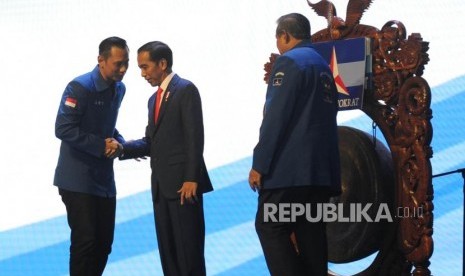 Presiden Joko Widodo (kedua kiri) berjabat tangan dengan Ketua Kogasma Partai Demokrat Agus Harimurti Yudhoyono (kiri) disaksikan oleh Ketua Umum Partai Demokrat Susilo Bambang Yudhoyono (kanan) saat membuka Rapat Pimpinan Nasional (Rapimnas) Partai Demokrat 2018 di Sentul International Convention Center (SICC), Bogor, Jawa Barat, Sabtu (10/3).