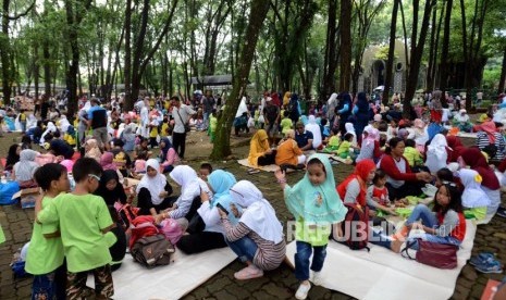 Pengunjung beristirahat saat berwisata di Kebun Binatang Ragunan, Jakarta, Kamis (7/3).