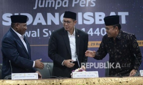 Menteri Agama Lukman Hakim Saifuddin (tengah) berjabat tangan dengan Ketua MUI Yusnar Yusuf (kanan) dan Ketua Komisi VIII DPR Ali Taher (kiri) usai memberikan keterangan Sidang Isbat di kantor Kementerian Agama, Jakarta, Senin (3/6).