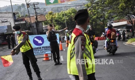 Petugas kepolisian melakukan pengaturan lalu lintas saat pengalihan arus lalu lintas di kawasan Cagak Nagreg, Kabupaten Bandung, Ahad (2/6).