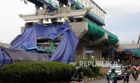 Kendaraan melintas di samping konstruksi proyek Light Rapid Transit (LRT) yang roboh di kawasan Jalan Raya Kayu Putih, Pulogadung, Jakarta Timur, Senin (22/1).