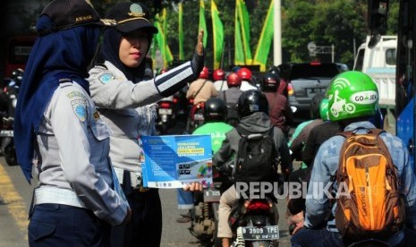 Petugas Dinas Perhubungan mengatur lalu lintas saat hari pertama uji coba perluasan ganjil genap di kawasan Pancoran, Jakarta Selatan, Senin (2/7).