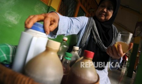 Sumiati (55) saat berjualan jamu tradisional di SDN Jatipadang 5, Pasar Minggu, Kamis (21/12).