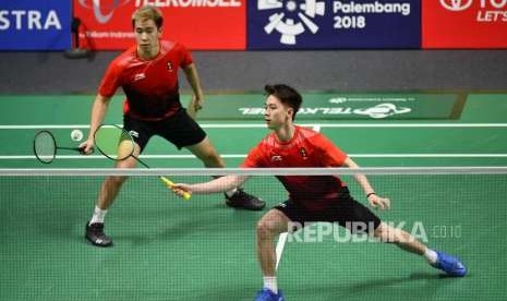 Pebulutangkis Ganda Putra Indonesia Marcus Fernaldi Gideon dan Kevin Sanjaya Sukamuljo berusaha mengembalikan kok pebulutangkis India saat berlaga pada nomor beregu putra perempat final cabang bulutangkis Asian Games 2018 di Istora Senayan, Jakarta, Senin (20/8).