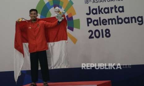 Pesilat Indonesia Abdul Malik berfoto pada penyerahan medali usai bertanding melawan pesilat Malaysia Muhammad Faizul M Nasir pada babak final cabang pencak silat putra kelas B 50-55 kg Asian Games 2018 di Padepokan Pencak Silat, TMII, Jakarta, Senin (27/8).