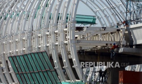 Sejumlah pekerja menyelesaikan pembangunan stasiun Kereta Light Rail Transit (LRT) di Jakarta, Jumat (4/1).