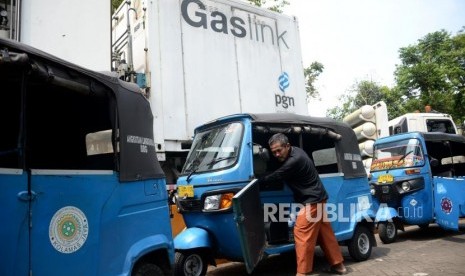 Pengemudi mendorong bajaj miliknya ketika mengantri saat mengisi BBG di Mobile Refueling Unit (MRU) milik PT Perusahaan Gas Negara (PGN) di Kawasan Monas, Jakarta, Ahad (21/10).