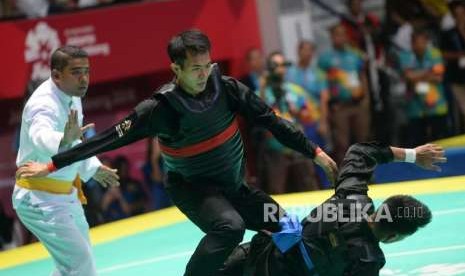 Pesilat Indonesia Komang Harik Adi Putra (pita merah) bertanding melawan pesilat Malaysia Mohd Al Jufferi Jamari pada babak final cabang pencak silat putra kelas E 65-70 kg Asian Games 2018 di Padepokan Pencak Silat,TMII, Jakarta, Senin (27/8).