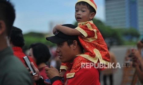 Seorang anak digendong orang tuanya saat menghadiri Perayaan Imlek Nasional 2019 di JI Expo Kemayoran, Jakarta, Kamis (7/2).