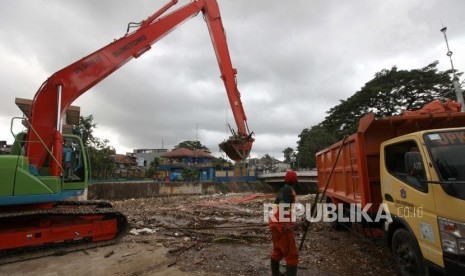 Petugas Dinas Lingkungan Hidup Pemprov DKI Jakarta mengoperasikan alat berat mengangkut sampah yang menumpuk di Pintu Air Manggarai, Jakarta, Ahad (8/4).