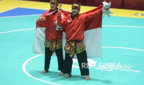 Pesilat Indonesia Ayu Sidan Wilantari dan Ni Made Dwiyanti memperlihatkan medali emas usai pertandingan cabang olahraga silat Asian Games 2018 kategori ganda putri di Padepokan Pencak Silat TMII, Jakarta, Rabu (29/8).