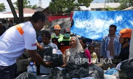 Tim Relawan ACT menyerahkan paket sembako secara simbolis kepada warga pengungsi di tempat pengungsian Duyu, Palu Barat, Kecamatan Tatanga, Selasa (9/10).