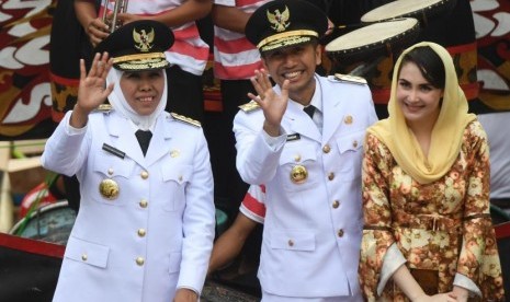 Gubernur Jawa Timur Khofifah Indar Parawansa (kiri) bersama Wakil Gubernur Jawa Timur Emil Elestianto Dardak (tengah) dan istrinya Arumi Bacshin (kanan) menyapa warga ketika diarak menuju Grahadi, Surabaya, Jawa Timur.