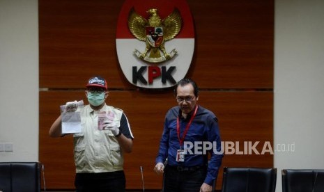 Wakil Ketua KPK Saut Situmorang beserta penyidik memperlihatkan barang bukti saat konferensi pers terkait kasus dugaan suap Tindak Pidana Korupsi memberikan atau menerima hadiah atau janji terkait pengadaan barang dan jasa di PT Krakatau Steel (Persero) Tahun 2019di Gedung Merah Putih KPK, Jakarta, Sabtu (23/3).