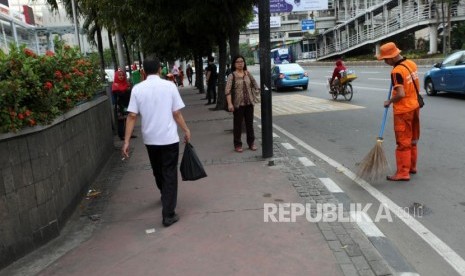 Petugas PPSU membersihkan sampah di Trotoar Kawasan MH Thamrin, Jakarta, Rabu (7/3).