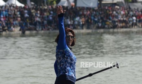 Menteri Kelautan dan Perikanan Susi Pudjiastuti dengan menaiki Paddle Board melambaikan tangan sebelum berlomba adu cepat dengan Wagub DKI Jakarta Sandiaga Uno dalam festival Danau Sunter, Jakarta, Ahad (25/2).