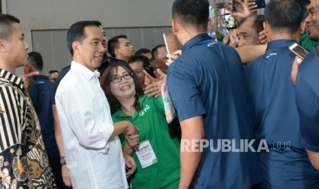 Presiden Joko Widodo (tengah) melayani permintaan swafoto oleh pengemudi online disela-sela Silatnas Keluarga Besar Pengemudi Online di Jakarta, Sabtu (12/1).