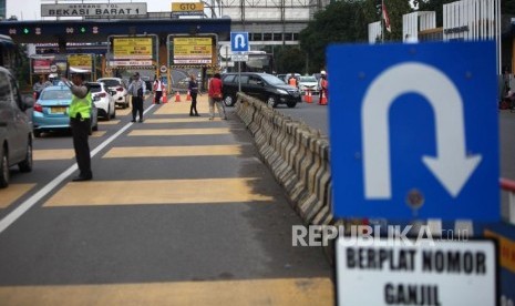 Kendaraan mobil dengan nomor polisi ganjil memutar balik saat hari pertama pemberlakuan sistem ganjil genap di Gerbang Tol Bekasi Barat 1, Bekasi, Jawa Barat, Senin (12/3).