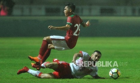 Gelandang Timnas Indonesia Septian David Maulana mendapat hadangan dari pemain Bahrain Mohamed Marhoon dalam laga PSSI Anniversary Cup 2018 di Stadion Pakansari, Cibinong, Bogor, Jumat (27/4) malam.