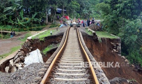 Kondisi jalur kereta api jurusan Sukabumi-Bogor yang menggantung akibat pondasi longsor di Kampung Maseng, Cijeruk, Kabupaten Bogor, Jawa Barat, Selasa (6/2).