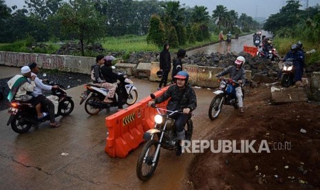 Pengendara motor melewati blokade Jalan Regional Ring Road (R3), Katulampa, Bogor, Jawa Barat.