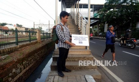 Sejumlah aktivis Koalisi Pejalan Kaki saat melakukan aksi Tamasya Trotoar di Jalan I Gusti Ngurah Rai, Klender, Jakarta Timur, Jumat (7/12).