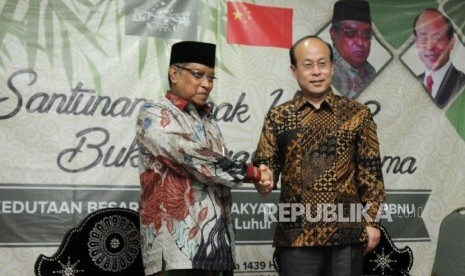 Ketua Umum PBNU KH Said Aqil Siroj (kiri) bersama Dubes Cina untuk Indonesia Xiao Qian (kanan) bersalaman pada acara penyerahan bantuan fasilitas sanitasi MCK, santunan yatim dan buka puasa bersama di Pondok Pesantren Luhur Al Tsaqafah, Ciganjur, Jakarta, Rabu (23/5).