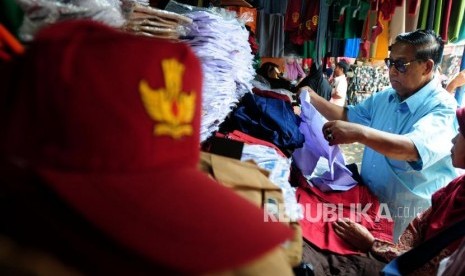 Warga memilih seragam sekolah di Pasar Jatinegara, Jakarta Timur, Rabu (4/7).