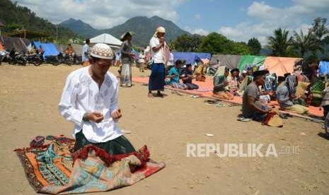 Korban bencana gempa bumi Lombok berdoa usai menunaikan ibadah shalat Jumat di pengungsian, Lombok Utara, Nusa Tenggara Barat, Jumat (10/8).