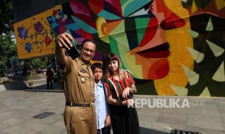 Gubernur DKI Jakarta Anies Baswedan bersama Seniman Kolombia Ledania berfoto selfie saat meninjau mural di Taman Ismail Marzuki, Jakarta, Senin (10/9).