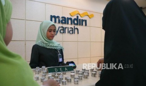 Via nasabah cilik Bank Syariah Mandiri (BSM) bersama ibunya menyetorkan uang koin hasil tabungannya di teller BSM Cabang Thamrin Jakarta, Rabu (16/5).