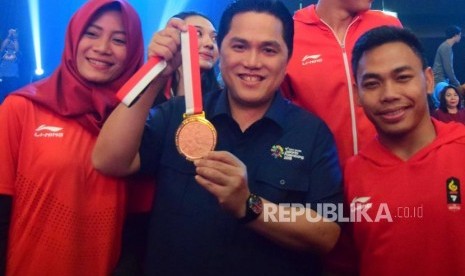 Ketua Panitia Asian Games Erick Thohir memegang medali emas bersama atlet Indonesia untuk Asian Games 2018 saat konser 50 hari menuju Asian Games 2018 di Jakarta, Sabtu (30/6).