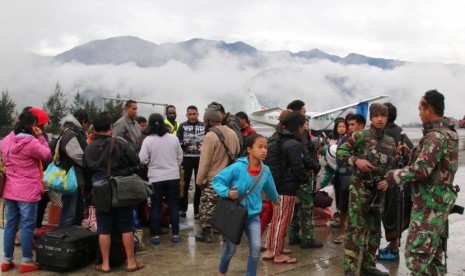 Warga menunggu pesawat dengan penjagaan aparat keamanan di Bandara Ilaga, Kabupaten Puncak, Papua, Rabu (2/10/2019).