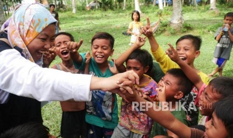 Seorang relawan ACT bermain dengan anak-anak di desa Lompio Kabupaten Sirenja, Donggala Sulawesi Tengah, Ahad (14/10).