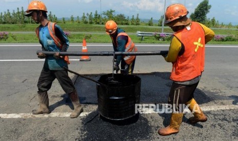 Pekerja saat menyelesaikan perbaikan jalan di Jawa Barat (ilustrasi)