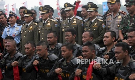 Gubernur DKI Jakarta Anies Baswedan bersama Wakil Gubernur DKI Jakarta Sandiaga Uno dan Kepala Satpol PP Yani Wahyu berfoto bersama personil Satpol PP saat menghadiri Apel besar dalam rangka memperingati HUT Satpol PP ke-68 di Lapangan Monas, Jakarta, Kamis (26/4).