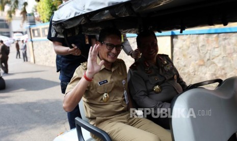 Wakil Gubernur DKI Jakarta Sandiaga Salahudin Uno (kiri) bersama Wakapolda Metro Jaya, Brigjen Pol Purwadi (kanan) menggunakan mobil golf seusai apel Mantap Praja Jaya 2017 di Polda Metro Jaya, Jakarta, Selasa (31/10).