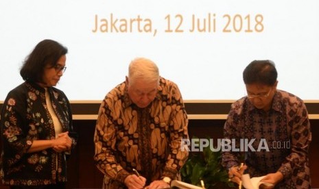 President Director of PT Inalum Budi Gunadi Sadikin (right) and CEO Freeport-McMoran Inc Richard Adkerson sign the Head of Agreement (HoA) for the divestment process in PT Freeport Indonesia (PTFI) witnessed by Finance Minister Sri Mulyani (left) at Finance Ministry Office, Jakarta, Thursday (July 12).